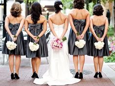 the bridesmaids are wearing black dresses and holding bouquets