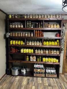 a shelf filled with lots of different kinds of jars and containers on top of wooden shelves