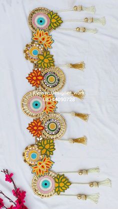 an assortment of decorative items on a white table cloth with flowers and beads in the background