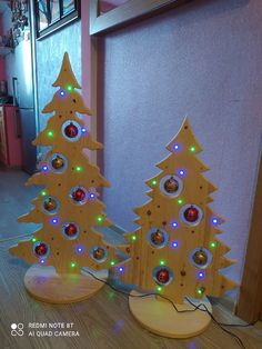 two wooden christmas trees with colorful lights on them