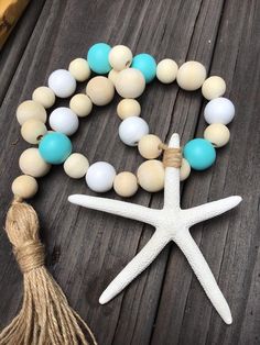 a white starfish and some beads on a wooden table