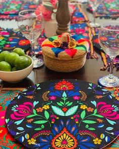 a colorful table setting with fruit and wine glasses