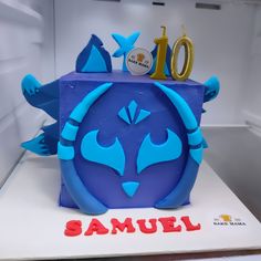 a cake with blue frosting and an image of a monster face on the top