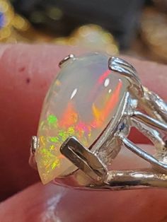 an opalite ring sitting on top of someone's finger