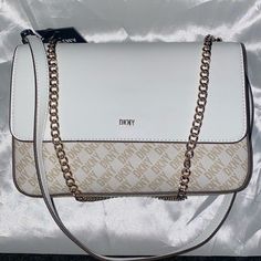 Dkny Sina-Md Flip Logo Shoulder Crossbody Bag White/Gold Sz Approx W-10”H-6.5”D-3” Brand New With Tags Dkny Sina Medium Flap Shoulder/Crossbody Bag. Signature Faux Leather Magnetic Closure, Outer Pocket, 2 Inner Compartments, 2 Zippered Pockets, 1 Pouch Pocket. Chain Slides So This Can Be Used As Either A Shoulder Or Crossbody Bag. Work Travel Bag, Dkny Bags, Pocket Chain, Dkny Bag, Casual Purse, Snakeskin Purse, Purse White, Girly Bags, Cross Body Purse