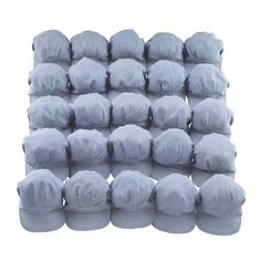 a pile of blue hats sitting on top of each other in front of a white background