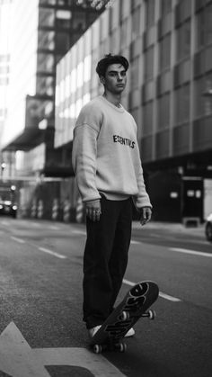 a young man is standing on his skateboard in the middle of an empty street