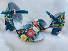 a pair of blue high heels with flowers on them