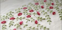 embroidered fabric with pink flowers and green leaves