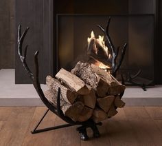 a fire place with logs stacked in front of it and an antler's head on top