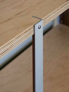 a close up view of a wooden table with metal frame and wood grain flooring