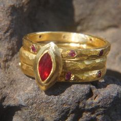 ruby ring //gold ruby ring//hammered engagement ring//24k gold engagement//artisan ruby ring//boho engagement ring this listing is for the complete set of three rings. Center ring is24k gold 3.2 mm wide. Center marquis ruby is 7x3mm. the side rings are 24k   2.6 mm wide   1.6 mm thick. the eight stones are 1.8 mm perfect natural Rubies   if you want a wedding ring to mach, just ask me and i will send you the details and options. In my years of experience i got the notion that many grooms bought the wrong design for her engagement ring. so I choose to pickup the glove on this and make my own collection of engagement ring. if you want a bigger stone contact me for pricing. Men , feel free to consult me with anything on this matter. I have presented a wedding ring that goes perfect with the e Hammered Engagement Ring, Boho Engagement Ring, Gold Ruby Ring, Boho Engagement, Ruby Ring Gold, Three Rings, Ruby Ring, Natural Ruby, Gold Engagement