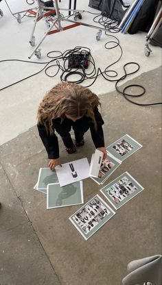 a person kneeling down on the ground in front of some pictures with their hands over them