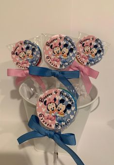 three minnie mouse lollipops in a bucket