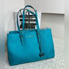 Nwot Beautiful Teal Michael Kors Bag. Medium Sized - Holds A Ton With Multiple Pockets On The Inside. Excellent Condition. For Sale...Genuine Michael Kors, Designer Tote, Handbag, Large Satchel, Beautiful Turquoise, Caribbean Blue Color, In Excellent Condition, No Dust Bag, Inside Is In Perfect Clean Condition No Rips Tears Etc. All Zippers In Working Order. Genuine Kors Lined With 4 Pockets One Zipper Pocket, Attached Key Finder. Bag Has A Metal Zipper Closure, Functions Fine, This Handbag Come Modern Blue Bags With Silver-tone Hardware, Elegant Blue Bag With Silver-tone Hardware, Elegant Turquoise Bag With Removable Pouch, Elegant Blue Bags With Silver-tone Hardware, Elegant Turquoise Shoulder Bag For Shopping, Elegant Turquoise Leather Bag, Elegant Turquoise Bag For Formal Occasions, Elegant Turquoise Shoulder Bag, Elegant Turquoise Tote Shoulder Bag