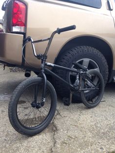 a bike that is sitting on the ground next to a truck with it's rear tire