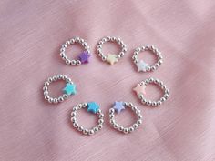 Product Description: Create a bold statement with our Pastel Shining Star Beaded Ring collection. These beautiful, handcrafted rings come in 7 designs: Yellow, White, Peach, Blue, Lilac, Purple, and Green. Each star is made of pastel beads threaded twice on elasticated cord for added security. The ring size is approximately UK size K but can stretch to fit up to a UK size P. Highlights: - Free delivery - Returns & exchanges accepted within 14 days of delivery - Etsy offsets carbon emissions for Elastic Rings, Beaded Star, Pastel Beads, Beaded Ring, Unique Fits, Kawaii Accessories, Handcrafted Rings, Shining Star, Star Ring