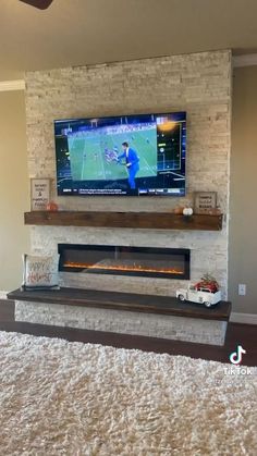 a flat screen tv mounted to the side of a wall above a fireplace in a living room