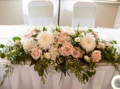 a table with flowers and greenery on it for a wedding reception at the hotel