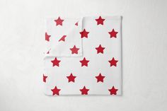 two red stars on white napkins sitting next to each other