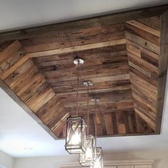 a wooden ceiling with several lights hanging from it's sides and wood planks on the ceiling