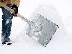 a man shoveling snow with an ice chest