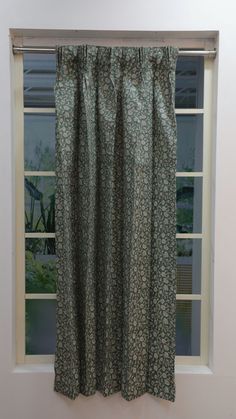 an open window with a green flowered curtain