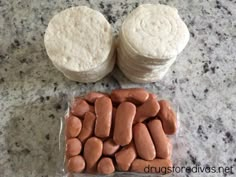 two round cakes sitting on top of a counter next to some small cookies and marshmallows