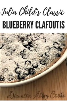 blueberry clafoutis with powdered sugar on top and the words julia child's classic