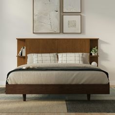 a bed with wooden headboard and two pictures above it on the wall behind it