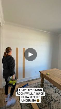 a woman standing in a living room holding a blow dryer next to a coffee table