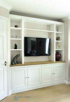 an entertainment center with built in cabinets and a flat screen tv