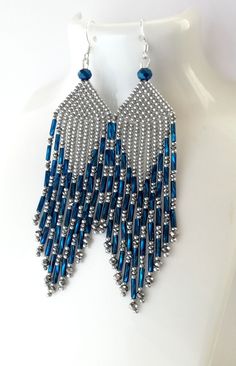 a pair of silver and blue beaded earrings on a white mannequin dummy