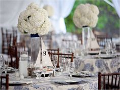 the table is set with white flowers in vases