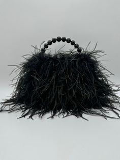 "Stand out from the crowd with this beautiful ostrich feather purse! This super cute bag is sure to add a touch of luxury and femininity to any outfit! Perfect for a night out on the town or any special event. *Black Agate stone bead handle  *Magnetic closure *Matching color satin interior. *Dust bag included *Dimensions are 7\" x 5\" x 2\" (Fits most phones!)   *Materials: Natural Ostrich Feathers,Natural Marabou Feathers, Vegan Leather, Friendly Felt, and Satin. *One year repair warranty  100% Handmade in Houston Texas Each item is made to order. This helps reduce fabric waste and lowers our cost which allows us to pass on those savings to our customers. Please allow up to 7 days processing time. Standard Shipping times are 3-5 days. If you need this item sooner, please send me a message Chic Formal Bags With Feathers, Formal Chic Bags With Feathers, Chic Formal Feather Bags, Chic Formal Feathered Bags, Chic Formal Bags With Feather Trim, Elegant Bags With Feather Trim For Events, Luxury Evening Bag With Feather Trim, Luxury Evening Bags With Feather Trim, Luxury Formal Bags With Feathers