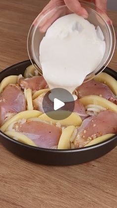 someone is adding mayonnaise to some food in a skillet on a wooden table