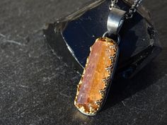 Raw Imperial Topaz crystal pendant, set in 14k gold and black sterling silver. Awesome as a single highlight or layered with other necklaces. Gorgeous gift for your 16th or 23rd wedding anniversary. Topaz is a December birthstone. > overall 33.5mm (1.31 inches) long Topaz pendant incl. the bail > 100% hand crafted from 14k yellow gold and sterling silver > genuine uncut Imperial Topaz gemstone crystal > black sterling silver necklace in the length of your choice The rough gemstone is an uncut, u Minimalist Topaz Jewelry As A Gift, Faceted Topaz Jewelry As A Gift, Faceted Citrine Pendant Jewelry, Unique Handmade Topaz Jewelry, Amber Faceted Pendant Jewelry, Topaz Pendant Necklace As A Gift, Topaz Pendant Necklace For Gifting, Fusion Style Faceted Necklace For Gift, Topaz Pendant Jewelry As A Gift