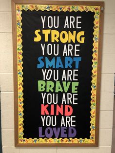 a classroom wall with a sign that says you are strong, you are smart and you are kind of loved