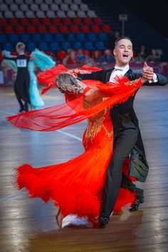 a man and woman in red dress dancing