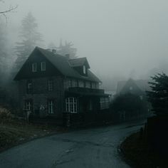 a foggy house with trees in the background