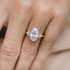 a woman's hand with a diamond ring on it