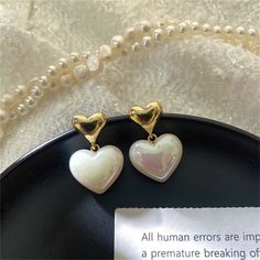 Gleaming pearls and bright 18k gold-plated metal meet in this shimmery drop earring pair featuring a classic heart motif. 0.62" W x 1.06" L 18k gold-plated copper / pearl Gold Double Heart Earrings For Mother's Day, Trendy Gold Hypoallergenic Heart Earrings, White Pearl Earrings For Valentine's Day Party, White Metal Heart Earrings For Gift, White Heart-shaped Pearl Earrings For Party, Gold Pearl Heart Earrings For Weddings, White Metal Heart Earrings Gift, White Metal Earrings For Valentine's Day, Trendy Gold Pearl Earrings