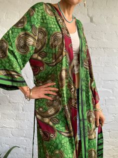 "This gorgeous green silky boho robe it is all fun to wear, boho inspired long and flowy and it is true retro style outfit It has comfortbale wrap tie closing, to fit easy most of sizes ( S-M ) It is perfect outfit for everyday around a house or as a boho street style cardigan PRODUCT SIZE One Size Fits Most length 55\" MATERIAL * vintage silk * No lining CARE INSTRUCTIONS * Wash separate in Cold water * Hand wash recommended * Hang to dry NOTE Please be aware that the colours shown on your moni Green Bohemian Wrap Kaftan, Fitted Bohemian Wrap Kimono, Green Bohemian Long Sleeve Robe, Green Long Sleeve Bohemian Robe, Hippie Long Green Kimono, Green Long Sleeve Kaftan For Loungewear, Bohemian Fitted Kimono For Festive Occasions, Green Wrap Kimono For Festival, Fitted Bohemian Kimono For Festive Occasions