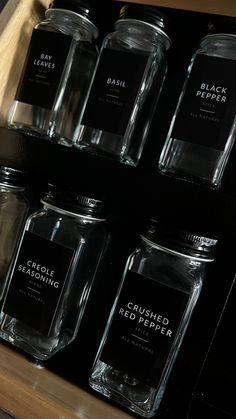 several glass jars with labels on them sitting on a shelf