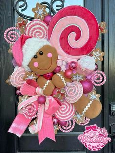 a christmas wreath with a teddy bear and candy canes on the front door,