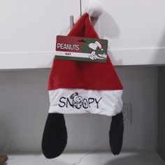 a santa hat hanging from the side of a kitchen counter with peanuts not snoopy on it