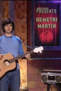 a man holding a guitar in front of a microphone