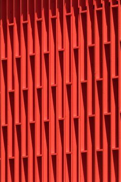 an orange wall that is very tall and has many vertical lines on it, with the top section missing