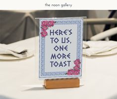 there is a sign that says here's to us, one more toast on the table