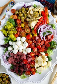 a white plate topped with lots of different types of food on top of a table